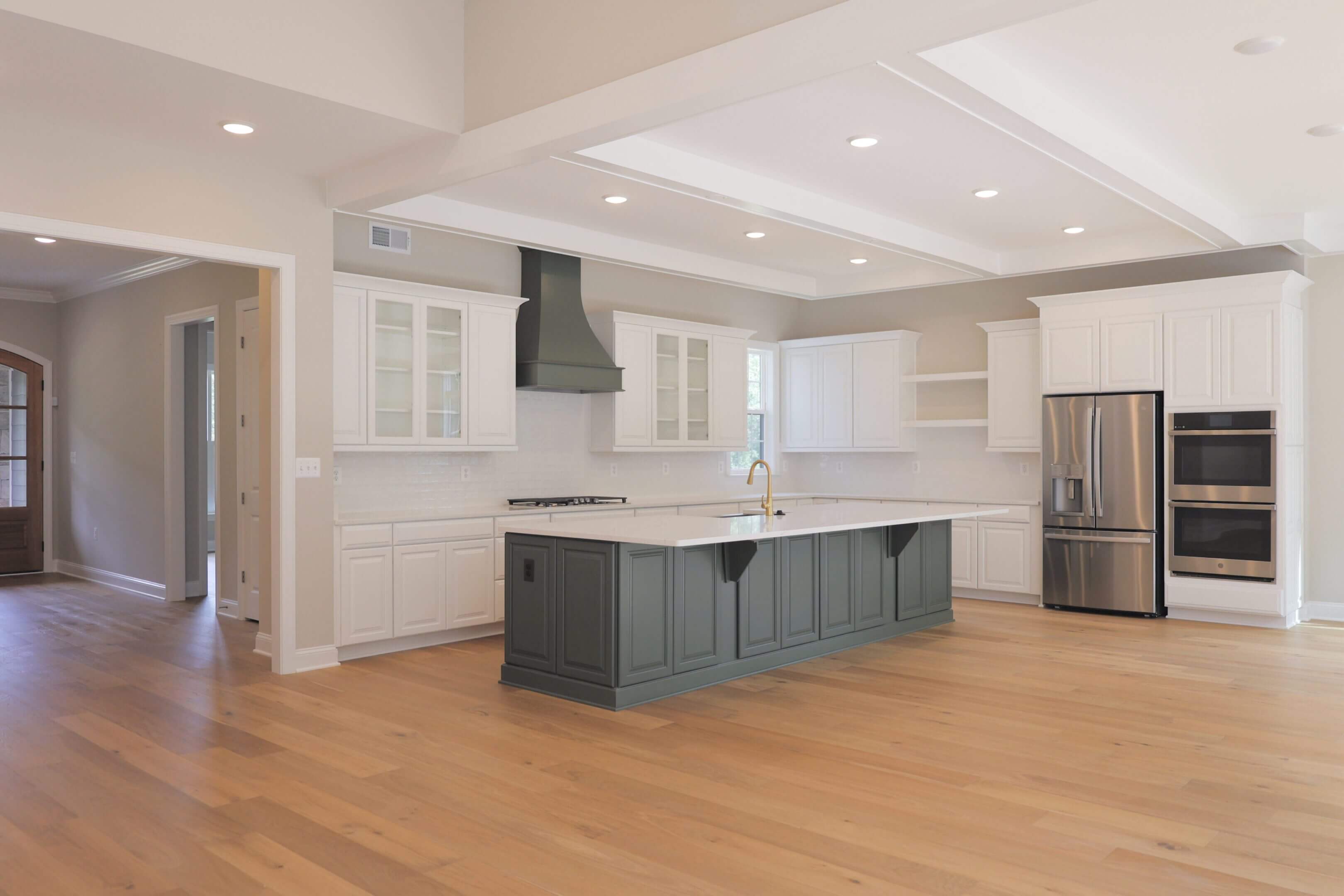 Modern kitchen with a large island and wooden floors.