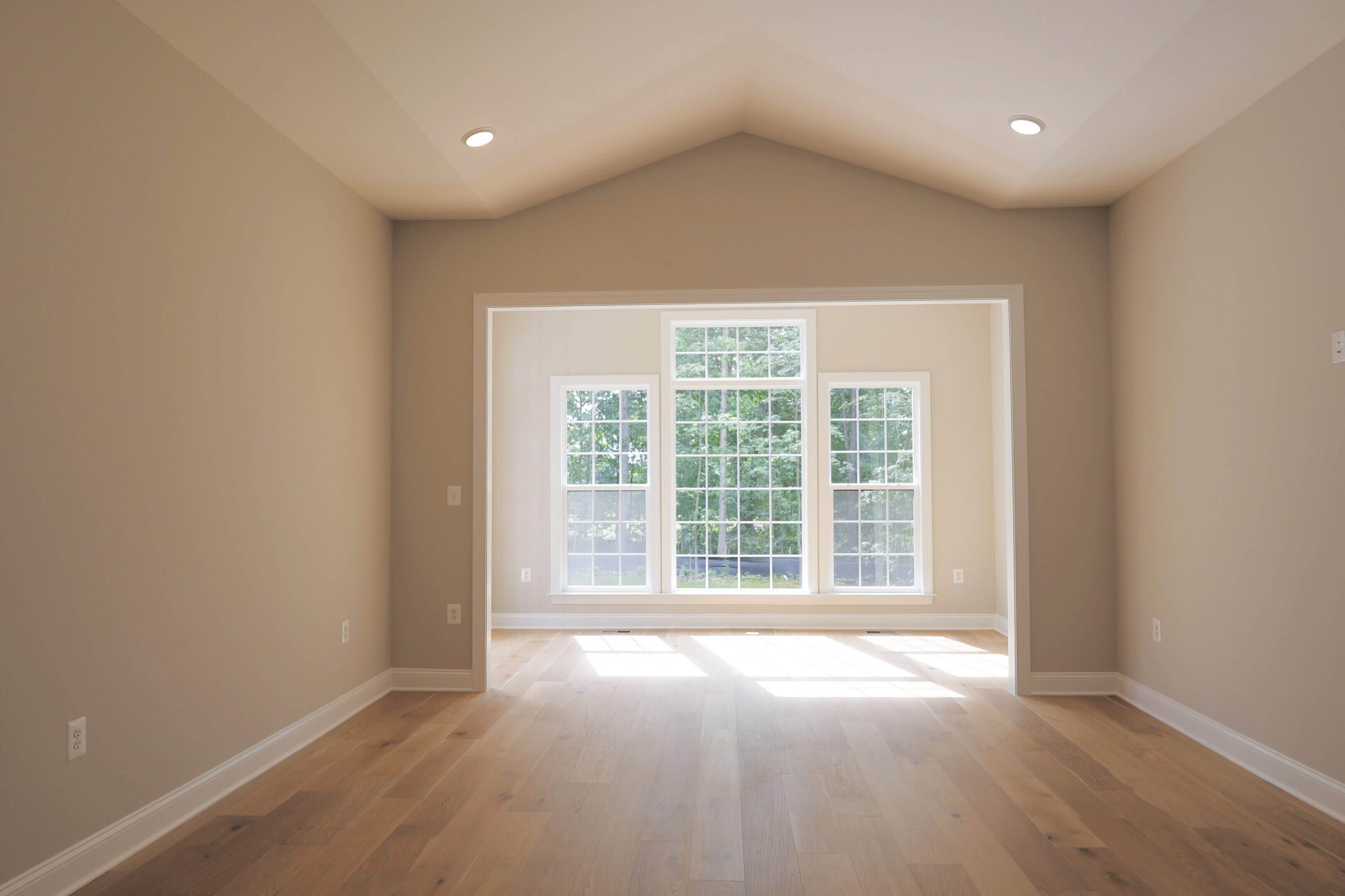 Empty room with large windows and natural light.